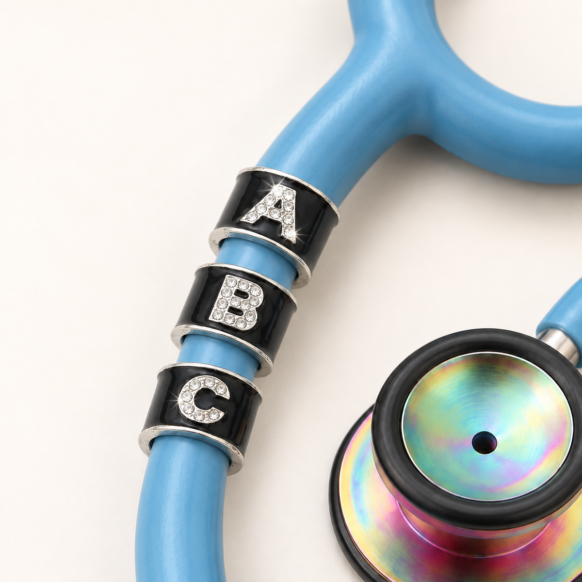 Bling Monogram Stethoscope Charm close-up on blue stethoscope
